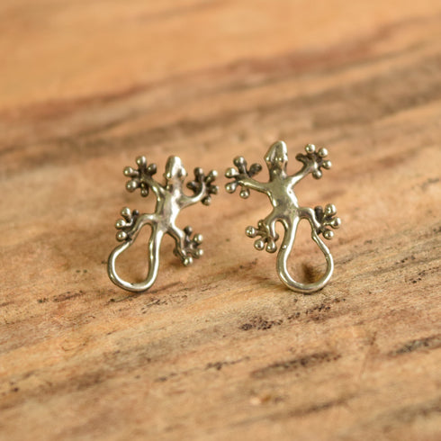 Sterling silver lizard gecko earrings on wood background