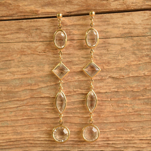 Long clear crystal drop earrings on wood background