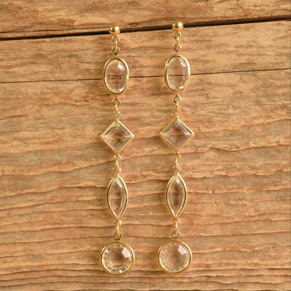 Long clear crystal drop earrings on wood background