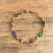 Gold filled bracelet featuring 8 gemstones carved into scarab beetles on a wooden background.