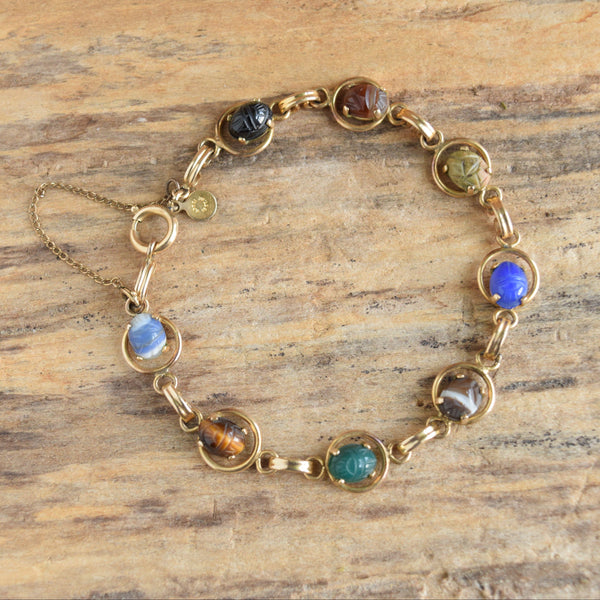 Gold filled carved gemstone scarab bracelet on wooden background