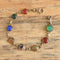 Multicolored round carved gemstone scarab bracelet on wood background