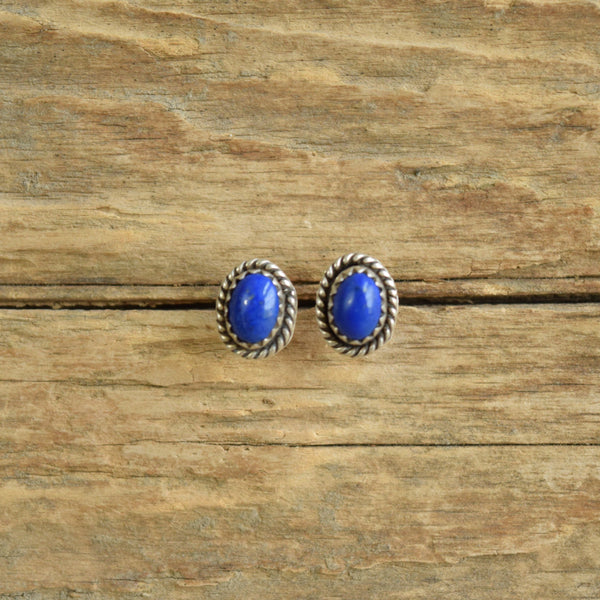 Lapis Lazuli stud earrings oval shaped on wood background