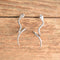 Sterling Silver twisty snake earrings by carlisle jewelry on wood