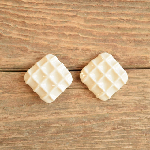 white waffle ceramic earrings on wood from the 1980's
