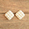 white waffle ceramic earrings on wood from the 1980's