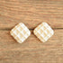 white waffle ceramic earrings on wood from the 1980's