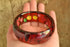 Prystal Bakelite - Reverse Carved and Painted Fruit and Vegetables Red Bakelite Bangle
